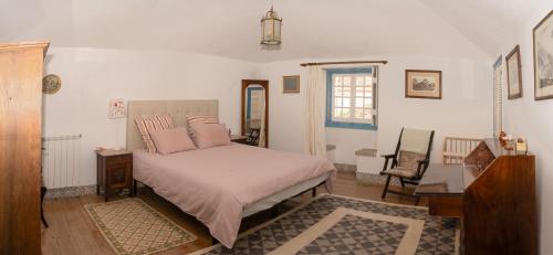 a bedroom with a bed with pink pillows on it at New Family Country House in Colares