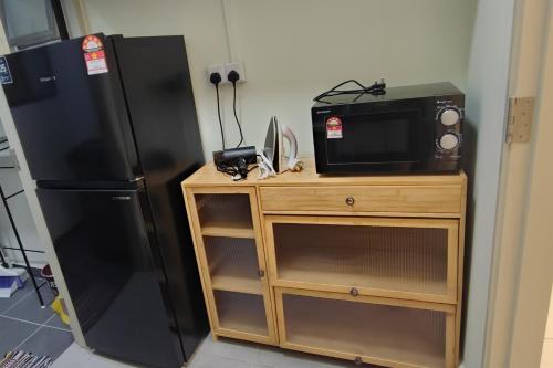 a kitchen with a black refrigerator and a microwave at Warm Nest near KLIA at Youth City Nilai by HCK in Nilai