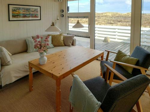 Una sala de estar con un sofá, una mesa y sillas. en Holiday Home Overlooking Protected Dune Heath, en Frøstrup