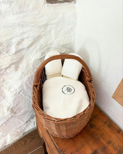 a wicker basket with a white chair sitting next to a wall at 17Th Century Renovated Barn In Valdeblore in Valdeblore