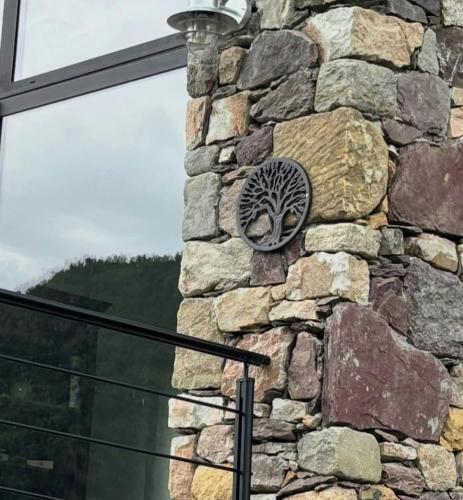 a stone wall with a tree plaque on it at 17Th Century Renovated Barn In Valdeblore in Valdeblore