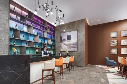 a restaurant with a bar with orange and blue chairs at Hampton by Hilton Shenzhen Longhua Qinghu in Shenzhen