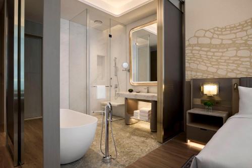 a bathroom with a tub and a sink and a bed at JW Marriott Hotel Chengdu in Chengdu