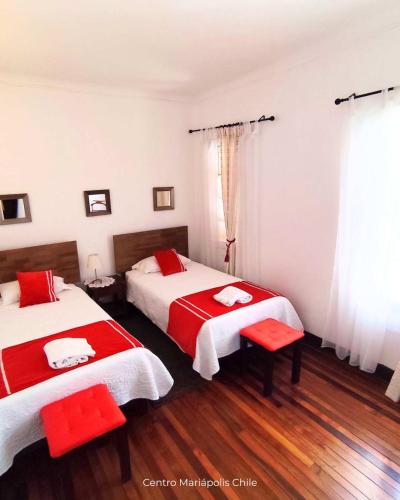 a bedroom with two beds with red and white sheets at Centro Mariápolis Chile in Cunaco