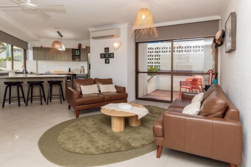 a living room with a couch and a table at Tranquil Noosa at its best Beach, Bush, Good Food. in Noosa Heads