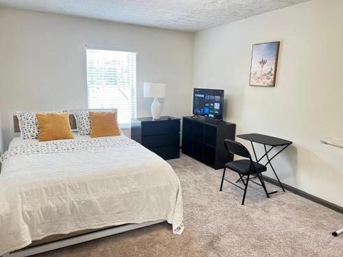 une chambre avec un lit, une chaise et une télévision dans l'établissement Entire cozy 2-bedroom Guest house in Atlanta, à Atlanta