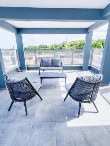 a patio with two chairs and a bench on a balcony at Tres Propiedades, Brisas del Mar l, Brisas del Mar II & Brisas del Mar lll in Fajardo