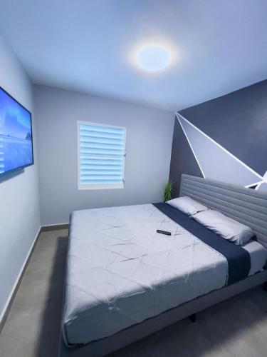 a bedroom with a large bed and a television at Tres Propiedades, Brisas del Mar l, Brisas del Mar II & Brisas del Mar lll in Fajardo