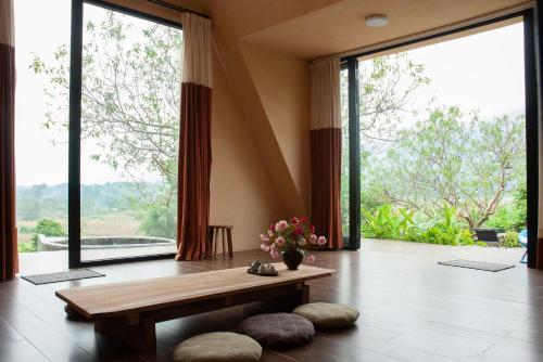 a living room with a bench and large windows at Warm Season 