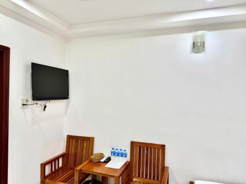 a room with two chairs and a table and a tv at Hà Tiên Hạnh Phúc Hotel in Ha Tien