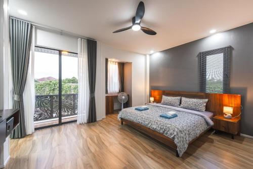 Ban Bang KhuにあるV215 ChaoFah Oasis Private Pool & Garden Retreatのベッドと大きな窓のある寝室