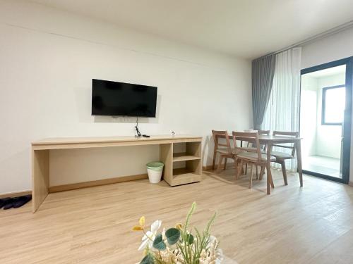 a living room with a television and a table with chairs at i24 Residence - Amata Phase 10 in Ban Mai (1)