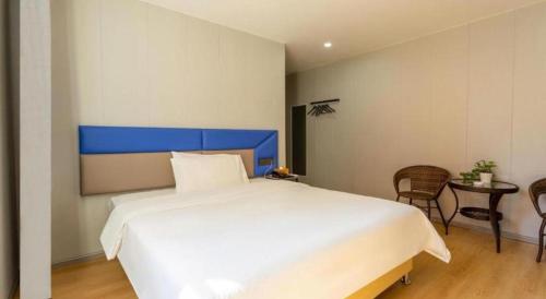 a bedroom with a large bed and a table and chairs at 7 Days Inn Xingyi Wanfenglin Xiawutun in Xiawutun