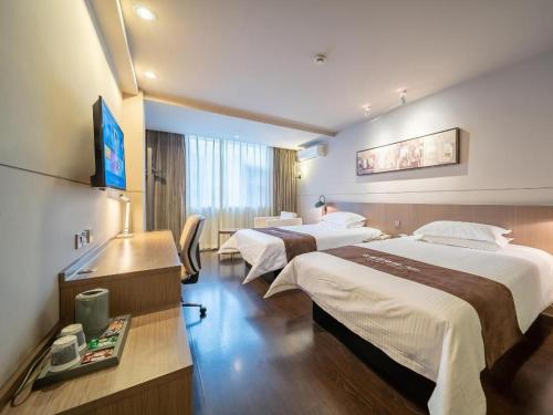 a hotel room with two beds and a television at Jinjiang Inn Select Xuzhou Suning Plaza Jinguang East Road in Xuzhou