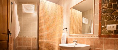 un baño con lavabo y espejo en Hotel Rural El Habanero, en Destriana