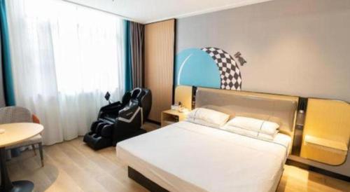 a bedroom with a bed and a table and a chair at City Comfort Inn Yingcheng Railway Station Shanghe Square in Xiaogan