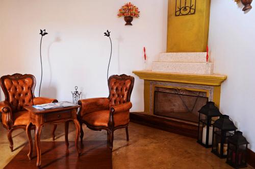 a living room with two chairs and a fireplace at Pousada Araujo Bazilio in Tiradentes