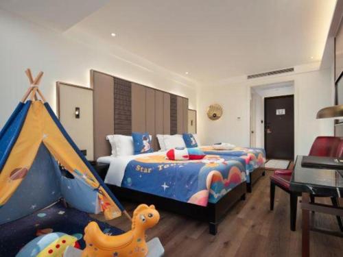 a bedroom with a bed and a play tent at Jinjiang Metropolo Haikou East High Speed Railway Station Normal University in Haikou