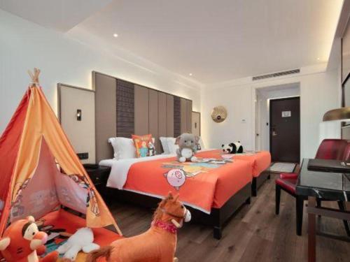 a bedroom with a bed with stuffed animals on it at Jinjiang Metropolo Haikou East High Speed Railway Station Normal University in Haikou