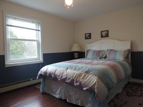 1 dormitorio con cama y ventana en Wright's Creek Apartment, en Charlottetown