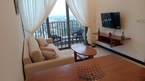 a living room with a couch and a flat screen tv at Colombo, Trizen Luxury Apartments, Sri Lanka in Colombo