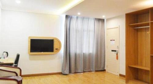 a living room with a tv and a curtain at PAI Hotels Shijiazhuang Railway Station West Square in Shijiazhuang