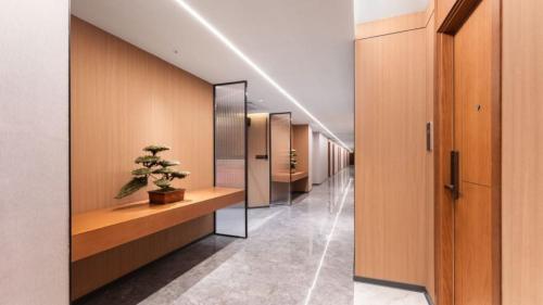a hallway with a row of mirrors and a potted plant at Xingdu International Smart Hotel Changgang Subway Station Branch in Guangzhou