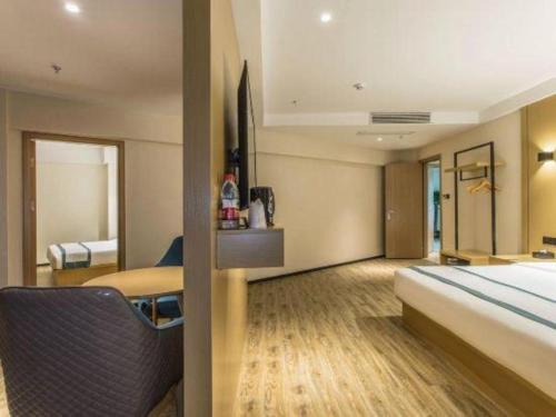 a hotel room with a bed and a bed and a bed at City Comfort Inn Liuzhou Liucheng in Liuzhou