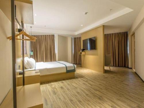 a hotel room with a bed and a television at City Comfort Inn Liuzhou Liucheng in Liuzhou