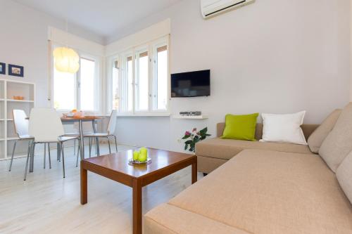 a living room with a couch and a table at Apartments Galatea with garage parking in Opatija