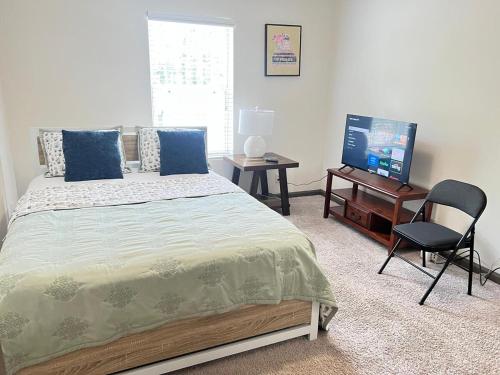 a bedroom with a bed and a television and a chair at Entire cozy 2-bedroom Guest house in Atlanta in Atlanta