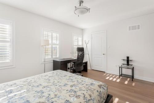 a white bedroom with a bed and a desk at Excellent luxury living in Milton