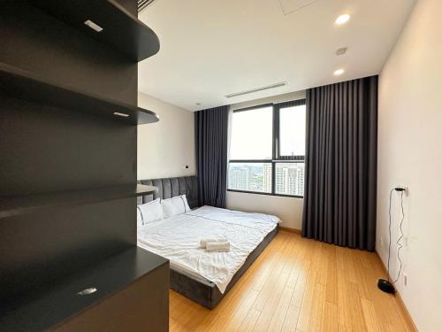 a bedroom with a bed and a large window at Chuỗi CHDV the Zei Lê Đức Thọ in Hanoi