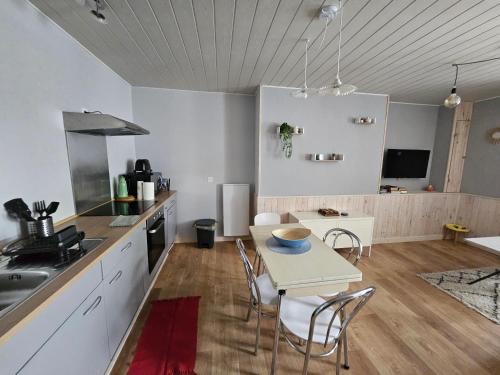 a kitchen with a table and chairs in a room at Studio proche centre-ville Dol-de-Bretagne in Dol-de-Bretagne