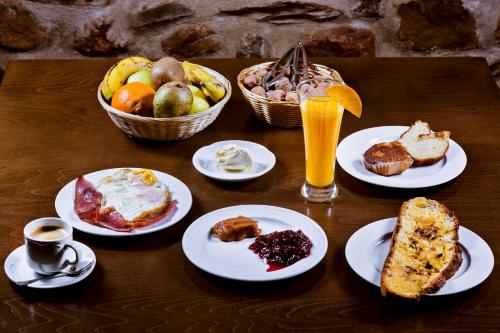 Una mesa cubierta con platos de desayuno y bebidas. en Hotel Rural El Habanero, en Destriana