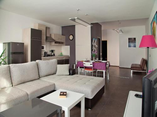 a living room with a couch and a kitchen at Apartments Bozena in Poreč