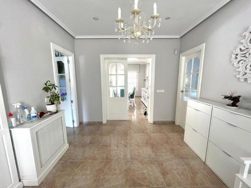 Una sala de estar con una lámpara de araña y un pasillo. en Villa de lujo al lado del mar, piscina, garaje wifi, AACC, en Alicante