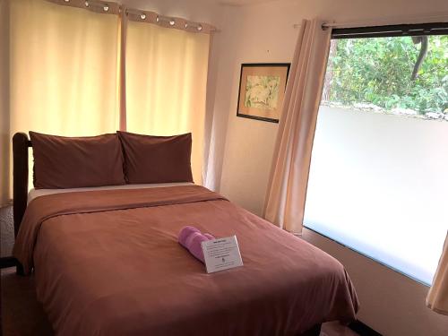 a bed with a pair of pink shoes sitting on it at Villa Formosa Panglao in Panglao
