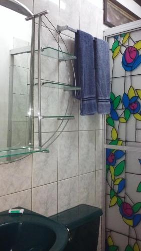 y baño con lavabo y ducha con toallas azules. en Cabinas Smith 2, en Cahuita