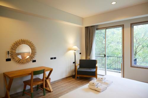 a room with a bed and a desk and a chair at The Leela Resort & Spa Pattaya in Pattaya