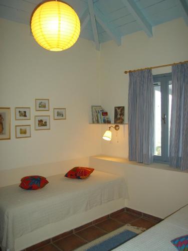 a bedroom with two beds and a lamp and a window at Il Suo Paradiso in Dhavgáta