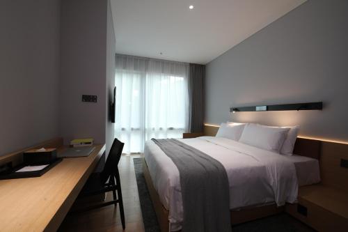 a hotel room with a bed and a desk with a bed sidx sidx sidx at Insio Hotel in Shenzhen