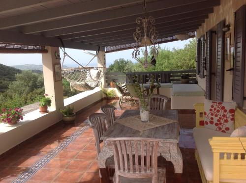 a patio with a table and chairs on a balcony at Il Suo Paradiso in Dhavgáta