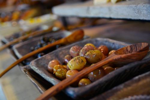 una ciotola di pomodori e cucchiai di legno su un tavolo di Cunda Zehra Teyzenin Evi a Ayvalık