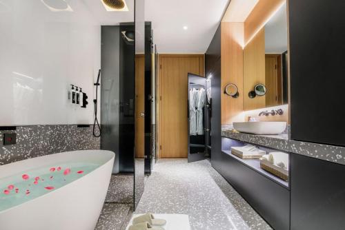 a bathroom with a tub and two sinks at Insio Hotel in Shenzhen