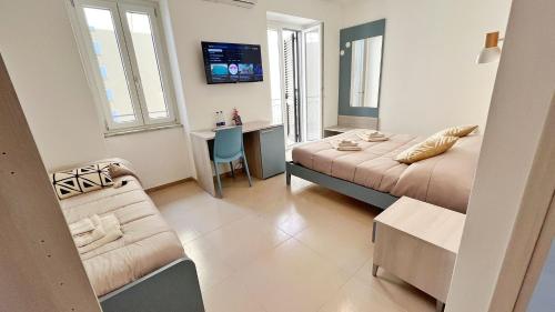 a hotel room with two beds and a couch at Flamingo Suites in Marina di Camerota