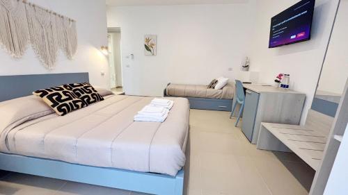 a bedroom with a bed and a desk in it at Flamingo Suites in Marina di Camerota