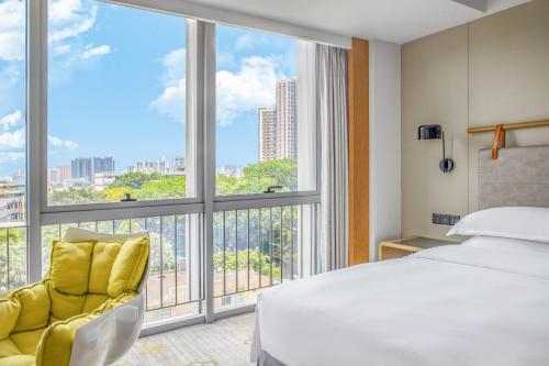 a hotel room with a bed and a large window at Holiday Inn Guangzhou South Lake hotel - Canton Fair free shuttle bus in Guangzhou