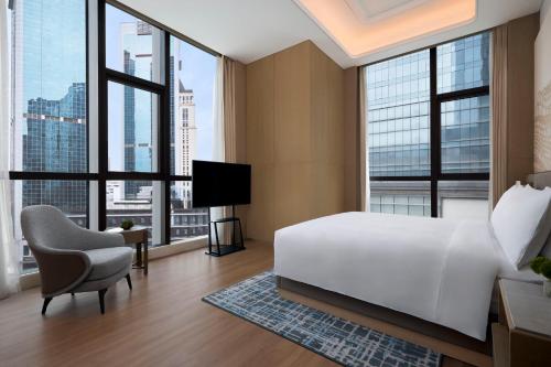 a bedroom with a white bed and large windows at JW Marriott Hotel Chengdu in Chengdu