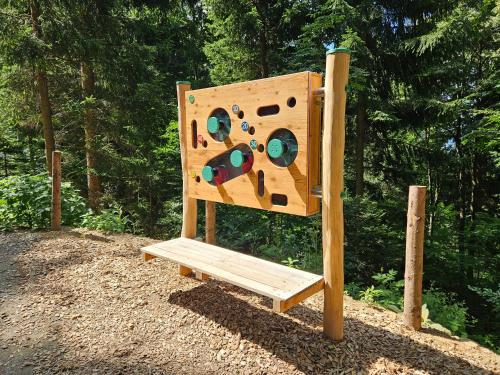 a wooden play structure in front of a forest at Großes Ferienhaus mit 5 Schlafzimmer & 4 Bäder in Pöllauberg